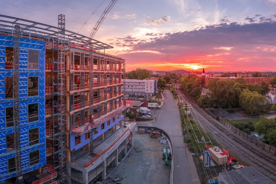 Large building under construnction in downtown Charlottesville, Virginia at sunset.